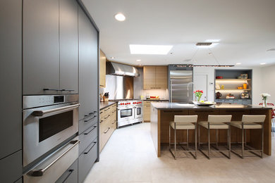 Photo of a medium sized contemporary l-shaped kitchen/diner in Dallas with a submerged sink, flat-panel cabinets, granite worktops, grey splashback, glass tiled splashback, stainless steel appliances, porcelain flooring, an island, beige floors and grey worktops.