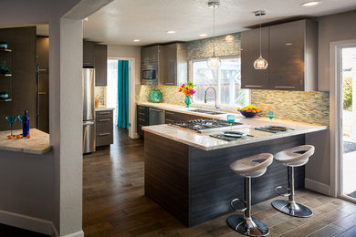 Example of a mid-sized trendy u-shaped eat-in kitchen design in San Francisco with a double-bowl sink, flat-panel cabinets, gray cabinets, quartzite countertops, glass tile backsplash, stainless steel appliances and a peninsula