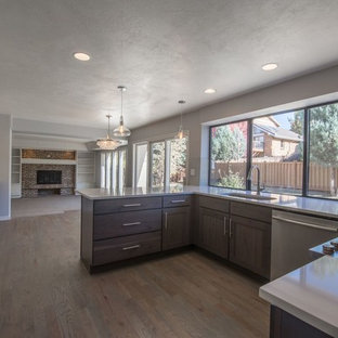 Design ideas for a mid-sized arts and crafts l-shaped eat-in kitchen in Denver with an undermount sink, shaker cabinets, grey cabinets, quartz benchtops, white splashback, subway tile splashback, stainless steel appliances, dark hardwood floors and a peninsula.