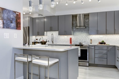 Design ideas for a medium sized contemporary l-shaped kitchen/diner in DC Metro with a single-bowl sink, flat-panel cabinets, grey cabinets, engineered stone countertops, yellow splashback, glass tiled splashback, stainless steel appliances, laminate floors, an island and white floors.