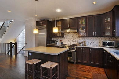 Inspiration for a contemporary l-shaped kitchen remodel in Chicago with dark wood cabinets, stainless steel appliances and an island