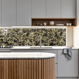 Zweizeilige, Kleine Moderne Wohnküche mit Doppelwaschbecken, grauen Schränken, Arbeitsplatte aus Terrazzo, schwarzen Elektrogeräten, hellem Holzboden, Kücheninsel und grauer Arbeitsplatte in Sydney