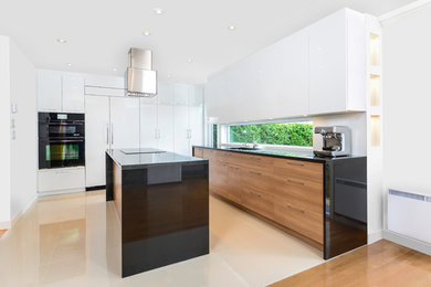 Immagine di una cucina design con paraspruzzi a finestra, elettrodomestici neri, pavimento beige, lavello sottopiano, ante lisce, top in granito e pavimento in gres porcellanato