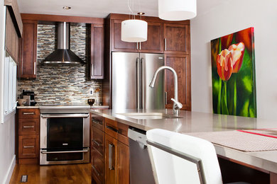 Example of a trendy eat-in kitchen design in Montreal with an undermount sink, shaker cabinets, brown cabinets, quartzite countertops, multicolored backsplash, glass tile backsplash and stainless steel appliances
