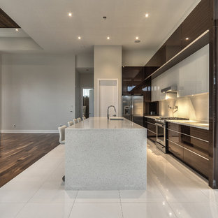 Esempio di un'ampia cucina a L moderna con ante di vetro, ante in legno bruno, top in quarzo composito, elettrodomestici in acciaio inossidabile e isola