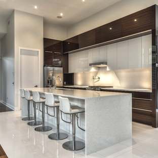 Ispirazione per un'ampia cucina a L minimalista con ante di vetro, ante in legno bruno, top in quarzo composito, elettrodomestici in acciaio inossidabile e isola