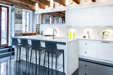 モントリオールにあるコンテンポラリースタイルのおしゃれなキッチン (白いキャビネット、白いキッチンパネル、シルバーの調理設備、磁器タイルの床、一体型シンク) の写真