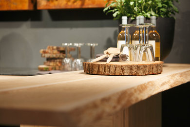 Diseño de cocina comedor tradicional renovada de tamaño medio con armarios estilo shaker, puertas de armario de madera clara, salpicadero verde y una isla