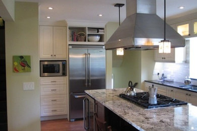 Mid-sized elegant u-shaped eat-in kitchen photo in Calgary with an undermount sink, recessed-panel cabinets, white cabinets, granite countertops, white backsplash, stone tile backsplash, stainless steel appliances and an island