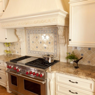 Eat-in kitchen - large mediterranean l-shaped medium tone wood floor and brown floor eat-in kitchen idea in Salt Lake City with an undermount sink, raised-panel cabinets, white cabinets, granite countertops, multicolored backsplash, ceramic backsplash, colored appliances, an island and beige countertops
