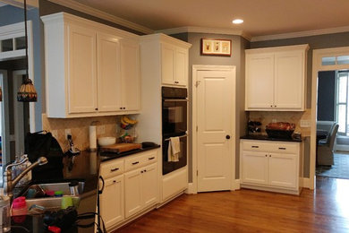 アトランタにあるコンテンポラリースタイルのおしゃれなキッチン (フラットパネル扉のキャビネット、濃色木目調キャビネット、御影石カウンター) の写真