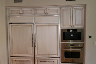 オースティンにあるお手頃価格の中くらいなトラディショナルスタイルのおしゃれな独立型キッチン (レイズドパネル扉のキャビネット、淡色木目調キャビネット、シルバーの調理設備) の写真
