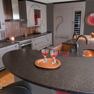 Imagen de cocina de galera, contemporánea, grande, abierta, con fregadero sobremueble, armarios con paneles lisos, puertas de armario grises, encimera de cuarzo compacto, salpicadero metalizado, salpicadero de metal, electrodomésticos con paneles, suelo de corcho y una isla