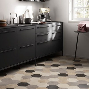 Design ideas for a small contemporary separate kitchen in San Francisco with a drop-in sink, flat-panel cabinets, black cabinets, black appliances, vinyl floors, no island, multi-coloured floor and black benchtop.