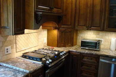 Eat-in kitchen - large craftsman u-shaped dark wood floor and brown floor eat-in kitchen idea in Other with raised-panel cabinets, dark wood cabinets, granite countertops, beige backsplash, ceramic backsplash, stainless steel appliances, a double-bowl sink and an island