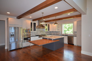 Inspiration for a modern l-shaped medium tone wood floor kitchen remodel in Richmond with an undermount sink, recessed-panel cabinets, white cabinets, gray backsplash, stainless steel appliances and an island