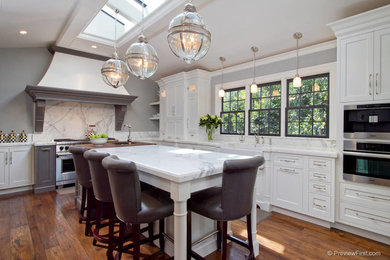 Photo of a classic u-shaped kitchen/diner in San Diego with a belfast sink, recessed-panel cabinets, white cabinets, marble worktops, white splashback, stone slab splashback and stainless steel appliances.