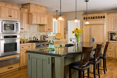 Diseño de cocina tradicional con electrodomésticos con paneles, armarios con paneles empotrados, puertas de armario de madera clara y barras de cocina