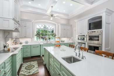 Inspiration for a timeless u-shaped dark wood floor, brown floor and coffered ceiling kitchen remodel in Austin with an undermount sink, raised-panel cabinets, green cabinets, an island and white countertops