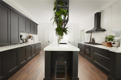 Mid-sized trendy galley enclosed kitchen photo in Montreal with shaker cabinets, black cabinets, quartzite countertops and an island
