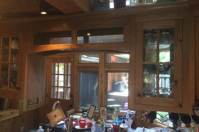 ブリッジポートにある小さなラスティックスタイルのおしゃれなキッチン (エプロンフロントシンク、ガラス扉のキャビネット、中間色木目調キャビネット、ベージュキッチンパネル、モザイクタイルのキッチンパネル、シルバーの調理設備、セラミックタイルの床) の写真
