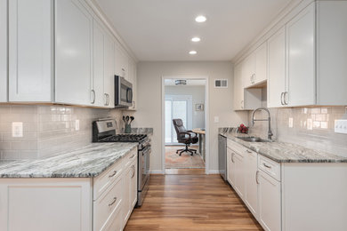 Eat-in kitchen - mid-sized transitional l-shaped brown floor eat-in kitchen idea in DC Metro with an undermount sink, shaker cabinets, white cabinets, quartzite countertops, gray backsplash, ceramic backsplash, stainless steel appliances, no island and gray countertops