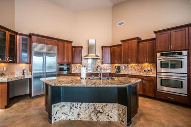 Large elegant u-shaped concrete floor and gray floor eat-in kitchen photo in Phoenix with raised-panel cabinets, dark wood cabinets, granite countertops, multicolored backsplash, stainless steel appliances and an island