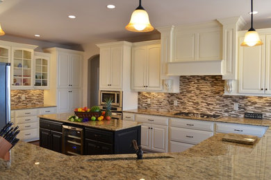 Photo of a large traditional u-shaped enclosed kitchen in Other with a submerged sink, raised-panel cabinets, white cabinets, granite worktops, multi-coloured splashback, glass tiled splashback, stainless steel appliances, dark hardwood flooring and an island.