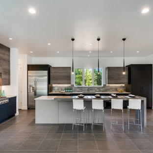 Photo of a large contemporary u-shaped open plan kitchen in Denver with an undermount sink, flat-panel cabinets, quartz benchtops, metallic splashback, metal splashback, stainless steel appliances, porcelain floors, multiple islands and grey floor.