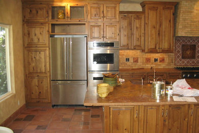 Terra-cotta tile kitchen photo in Los Angeles with a farmhouse sink, raised-panel cabinets, light wood cabinets, granite countertops, beige backsplash, terra-cotta backsplash, stainless steel appliances and an island