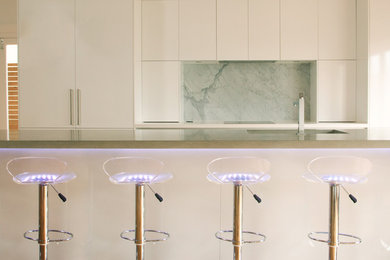 Foto de cocina lineal actual con fregadero bajoencimera, encimera de cemento, salpicadero blanco y una isla
