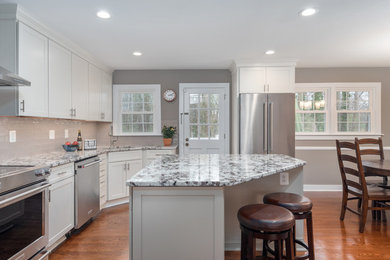 Mid-sized transitional l-shaped medium tone wood floor and brown floor eat-in kitchen photo in DC Metro with an undermount sink, shaker cabinets, white cabinets, quartzite countertops, beige backsplash, subway tile backsplash, stainless steel appliances, an island and multicolored countertops