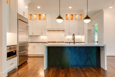 Inspiration for a large modern l-shaped medium tone wood floor, brown floor and shiplap ceiling eat-in kitchen remodel in Nashville with a farmhouse sink, shaker cabinets, white cabinets, quartzite countertops, white backsplash, ceramic backsplash, stainless steel appliances, an island and multicolored countertops
