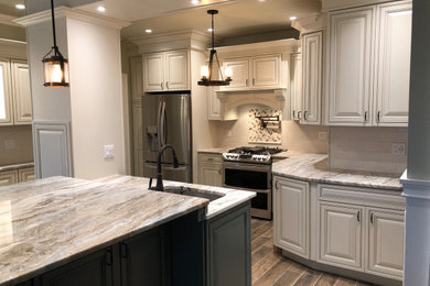 Example of a large classic eat-in kitchen design in New York with raised-panel cabinets, white cabinets, quartzite countertops and an island
