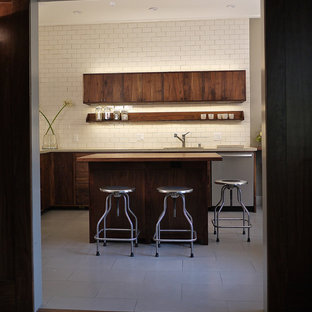 Photo of a mid-sized modern l-shaped separate kitchen in San Francisco with an undermount sink, flat-panel cabinets, dark wood cabinets, white splashback, subway tile splashback, stainless steel appliances, ceramic floors, with island and limestone benchtops.