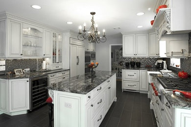 Mid-sized elegant u-shaped porcelain tile and black floor eat-in kitchen photo in New York with a farmhouse sink, beaded inset cabinets, white cabinets, granite countertops, metallic backsplash, mosaic tile backsplash, paneled appliances, an island and black countertops