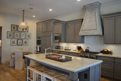 ヒューストンにある高級な広いおしゃれなキッチン (ダブルシンク、珪岩カウンター、白いキッチンパネル、ガラスタイルのキッチンパネル、シルバーの調理設備) の写真