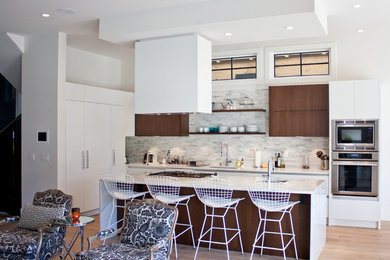 Mid-sized minimalist eat-in kitchen photo in Vancouver with flat-panel cabinets, white cabinets, solid surface countertops, white backsplash, marble backsplash and an island