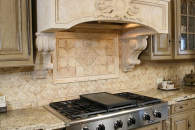 Inspiration for a large timeless travertine floor kitchen remodel in Orange County with raised-panel cabinets, distressed cabinets, granite countertops, beige backsplash, porcelain backsplash, stainless steel appliances and an island