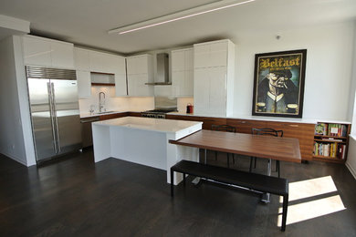 Foto de cocinas en L actual grande con fregadero bajoencimera, armarios con paneles lisos, puertas de armario blancas y una isla
