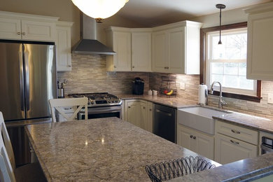 Example of a mid-sized transitional l-shaped kitchen design in Other with a farmhouse sink, raised-panel cabinets, white cabinets, granite countertops, multicolored backsplash, matchstick tile backsplash, stainless steel appliances, an island and brown countertops