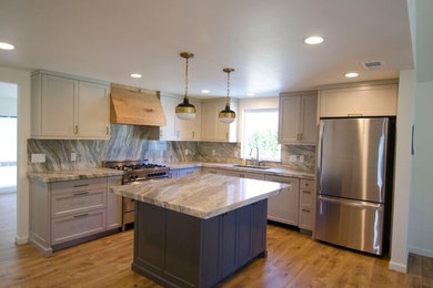 Example of a large transitional l-shaped medium tone wood floor eat-in kitchen design in Other with an undermount sink, shaker cabinets, gray cabinets, stainless steel appliances, an island, marble countertops, multicolored backsplash and stone slab backsplash