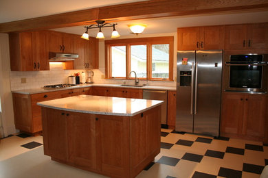 Eat-in kitchen - mid-sized traditional l-shaped linoleum floor eat-in kitchen idea in Burlington with an undermount sink, flat-panel cabinets, medium tone wood cabinets, granite countertops, white backsplash, ceramic backsplash, stainless steel appliances and an island