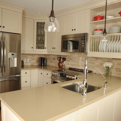 Small country u-shaped medium tone wood floor kitchen photo in Toronto with an undermount sink, shaker cabinets, white cabinets, solid surface countertops, beige backsplash, stone tile backsplash, stainless steel appliances and a peninsula