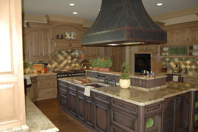 Klassisk inredning av ett u-kök, med en rustik diskho, luckor med upphöjd panel, skåp i ljust trä, granitbänkskiva, flerfärgad stänkskydd och stänkskydd i mosaik