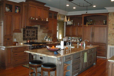 Example of a large classic l-shaped dark wood floor eat-in kitchen design in Other with an undermount sink, raised-panel cabinets, dark wood cabinets, granite countertops, beige backsplash, ceramic backsplash, stainless steel appliances and an island