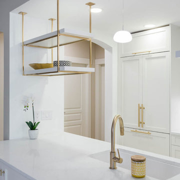 Custom-made hanging shelves in brass in a shaker style kitchen
