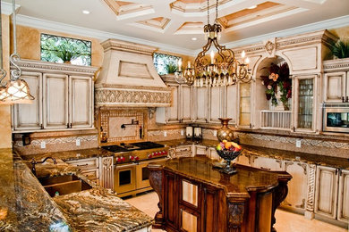 Inspiration for a large mediterranean u-shaped kitchen remodel in Miami with distressed cabinets, raised-panel cabinets, granite countertops, stainless steel appliances and an island