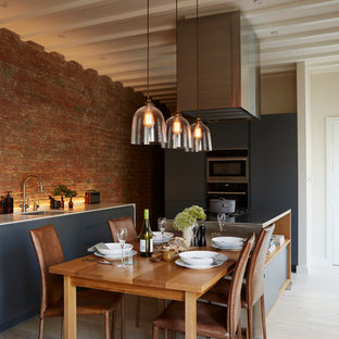 Mid-sized contemporary eat-in kitchen pictures - Eat-in kitchen - mid-sized contemporary light wood floor and exposed beam eat-in kitchen idea in London with stainless steel appliances and an island