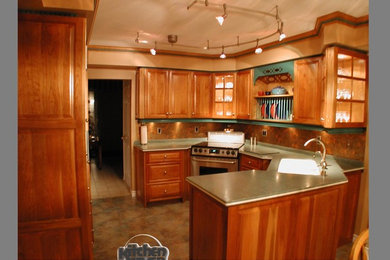 Immagine di una cucina ad U tradizionale di medie dimensioni con lavello integrato, ante con bugna sagomata, ante in legno scuro e top in superficie solida